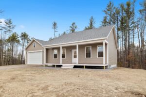 A manufactured house in the countryside with a gabled roofline and a front porch